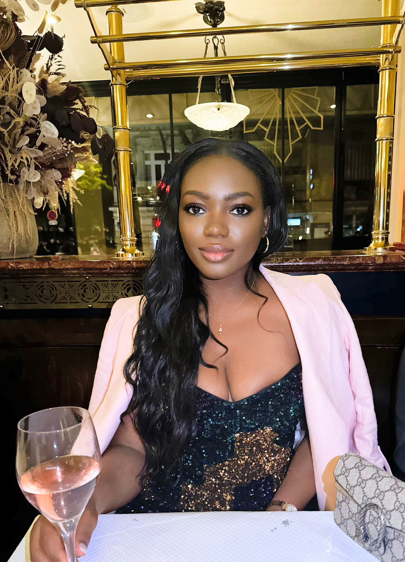 Julie Don in a sequin dress and pink blazer at a Paris bistro